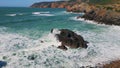 Stormy sea water splashing on coastal rocks sunny day. Drone rocky coastline Royalty Free Stock Photo