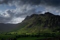 Stormy skies and a bright sun trace light over The Langdale Pikes in the English Lake District Royalty Free Stock Photo