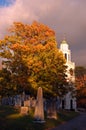 Stormy skies encroach on a classic church and fall foliage