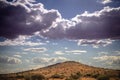 Stormy sky and promising rain clouds over a dry Kalahari desert hill