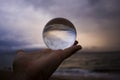 Stormy Sky and Sea at Sunset Captured in Glass Ball Held in Palm Royalty Free Stock Photo