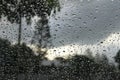 Stormy tropical scenery through window with rain drops background