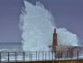 Stormy wave over old lighthouse and pier of Viavelez. Royalty Free Stock Photo