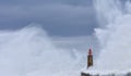 Stormy wave over old lighthouse and pier of Viavelez. Royalty Free Stock Photo