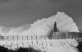 Stormy wave over old lighthouse and pier of Viavelez.