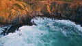 Stormy waves crashing coastal rocks. Aerial sea water breaking stone cliff coast Royalty Free Stock Photo