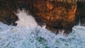Stormy waves splashing crashing high rocks aerial view. Dangerous ocean foaming. Royalty Free Stock Photo