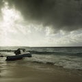 Stormy weather and fishing boat stranded on a beach Royalty Free Stock Photo