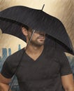 Closeup of a casually dressed handsome guy with an umbrella in the rain