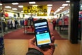 Smartphone with giant online retailer Amazon homepage in hand of customer entering a store