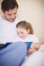 Story with a happy ending. A devoted father reading his young daughter a bedtime story.