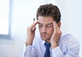 Story of my life - overworked and underpaid...a stressed-out businessman sitting with his hands to his head. Royalty Free Stock Photo