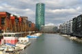 30-story skyscraper Westhafen Tower in Gutleitviertel district, buildings on river Main shore, boats, yachts moored on banks,