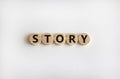 Story symbol. The word `story` on wooden circles on white table. Beautiful white background, copy space. Business and story