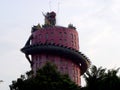 17-story tall pink cylindrical temple with a gigantic red and green dragon sculpture that curls across the entire height