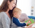 Story time is his favourite time. a mother reading a book to her baby boy at home. Royalty Free Stock Photo