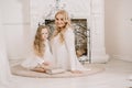 Story Time with Mother and Daughter in Front of Fireplace. Pretty family with book. Mom and child sitting close and Royalty Free Stock Photo