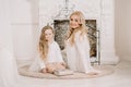 Story Time with Mother and Daughter in Front of Fireplace. Pretty family with book. Mom and child sitting close and Royalty Free Stock Photo