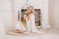 Story Time with Mother and Daughter in Front of Fireplace. Pretty family with book. Mom and child sitting close and Royalty Free Stock Photo