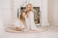 Story Time with Mother and Daughter in Front of Fireplace. Pretty family with book. Mom and child sitting close and Royalty Free Stock Photo