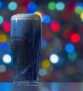 A Stouts with christmas lights on the background. Guinness dark Irish dry stout beer glass from a brewery in dublin. Royalty Free Stock Photo