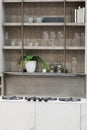 Stove closeup in modern kitchen interior. Gas burners built into the countertop. Hanging glass shelves with glasses Royalty Free Stock Photo