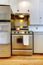 Stove and refrigerator steal with white kitchen.