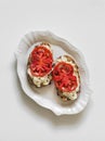 Stracciatella cheese, bruschetta tomatoes on a light background, top view