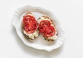 Stracciatella cheese, bruschetta tomatoes on a light background, top view