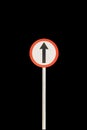 Straight arrow with red edge circular badge with old rusted iron pole. Traffic sign signage. isolated with black background Royalty Free Stock Photo