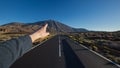 Straight asphalt road with finger wich shows peak of Pico del Teide volcano in background Royalty Free Stock Photo