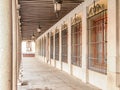 Straight corridor between pillars and wall with windows in an old historic building Royalty Free Stock Photo