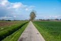 Straight cycling road through the agriculture fields of Geetbets, Belgium Royalty Free Stock Photo