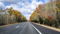 Straight flat highway lined with autumnal scenic maple trees in Massachusetts Royalty Free Stock Photo