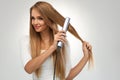 Straight Hair. Beautiful Woman Ironing Long Blonde Hair Royalty Free Stock Photo