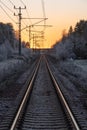 Straight rail road tracks into a beautiful orange sunset