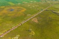 Straight railroad track through green countryside landscape in spring, drone pov