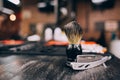 Straight razor, brush for shaving beard along with bowl, blurred background of hair salon for men, barber shop Royalty Free Stock Photo