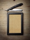 Straight razor and kraft poster on wood desk