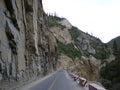 A straight road leads to the front under the jagged stone mountain