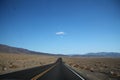 Straight road towards mountain range in horizon at Death Valley Royalty Free Stock Photo