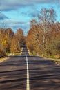 A straight road with a white line in the middle of the hill. Autumn Royalty Free Stock Photo