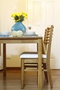 Straight shot of a wooden dining table and chair with table setting
