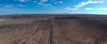 Straight tar road to the horizon in semi-desert landscape with clear blue sky and light clouds Royalty Free Stock Photo