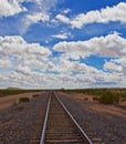 Straight tracks to horizon, cloudy skies Royalty Free Stock Photo