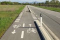 Straight two way cycle lane along side an asphalt road in the countryside. Royalty Free Stock Photo