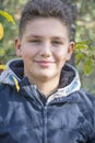 Straight on view of a young smiling boy outside in the forest