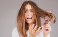 Straightening woman and treatment of the hair. Girl with straight brushed hair. Hair tangling problem. Unhappy girl with