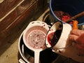 Straining grape juice through a colander