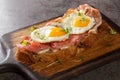 Strammer Max is a German open faced sandwich with ham and eggs closeup on the wooden board. Horizontal